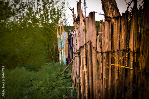 old vintage wooden fence in barbed wire in Bush in summer