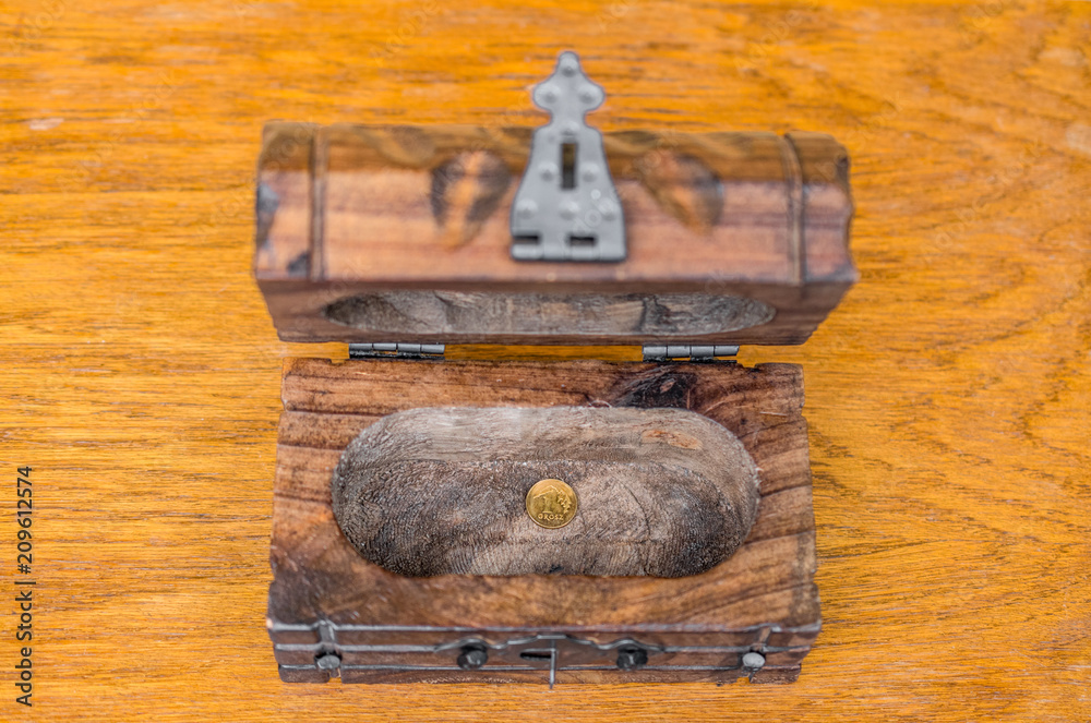 One hundredth of a Polish zloty (grosz) coin left in a vintage wooden box. Concept of personal savings or state treasury running low Close up, wooden background One hundredth of a Polish zloty (grosz) coin left in a vintage wooden box. Concept of personal savings or state treasury running low Close up, wooden background