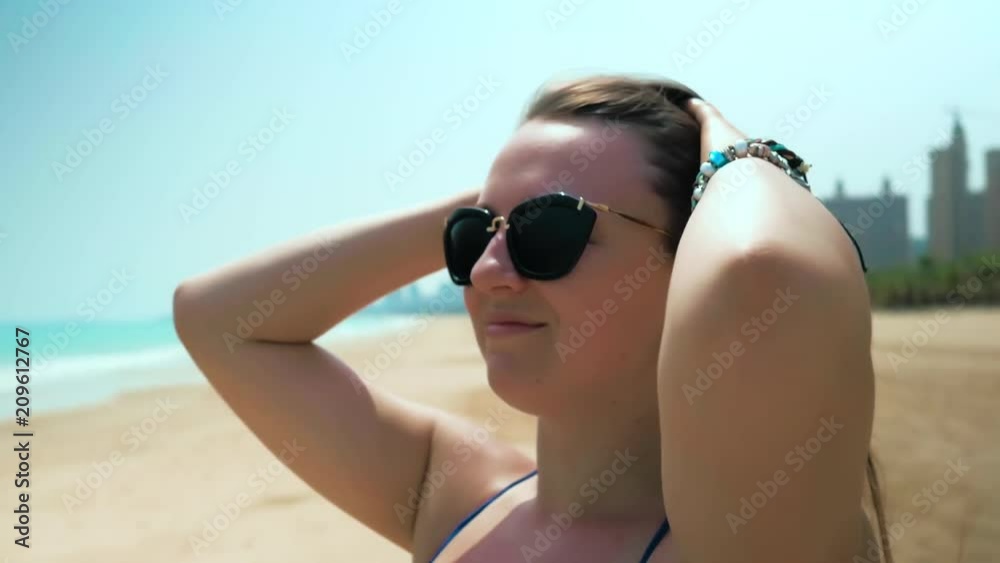 Young girl on beach adjusts her hair. Close Up Shot. Colorful. Slow Motion Young girl on beach adjusts her hair. Close Up Shot. Colorful. Slow Motion