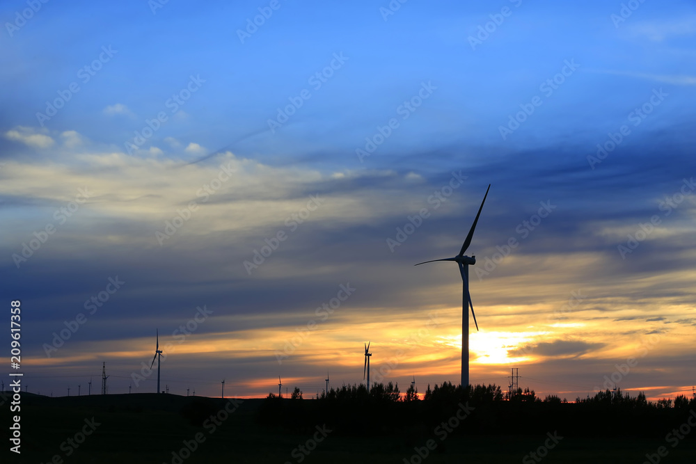 Obraz premium The silhouette of the windmill in the sunset