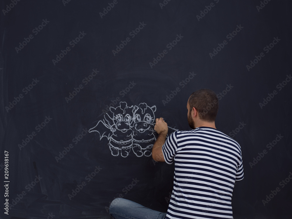 future dad drawing his imaginations on chalk board