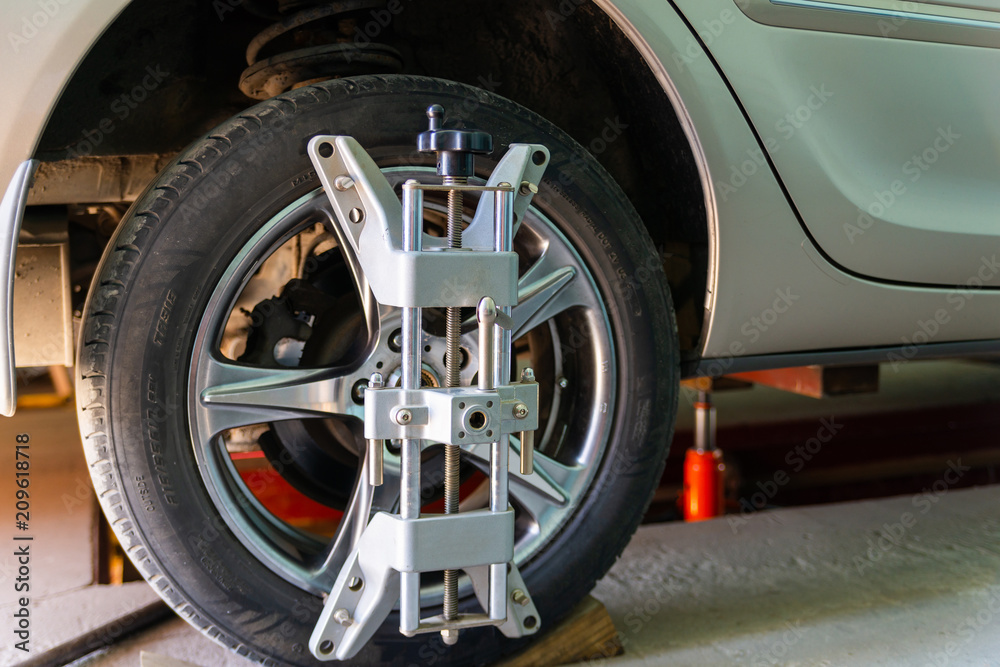 Car on stand with sensors on wheels for wheels alignment camber check in workshop of Service station