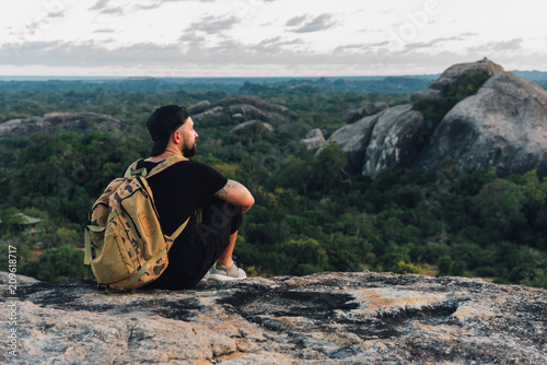 tranqul man sitting on the big stone in the forest photo