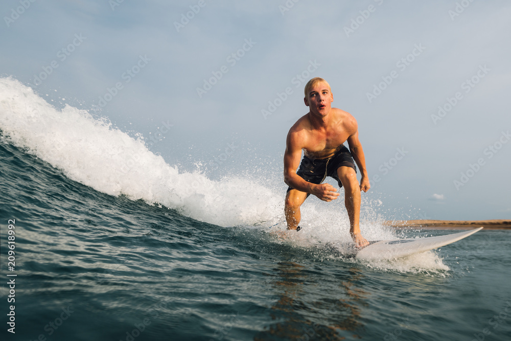   guy swims on a surf on a blue wave
