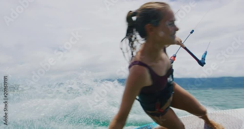 Beautiful young woman kitesurfing in slow motion