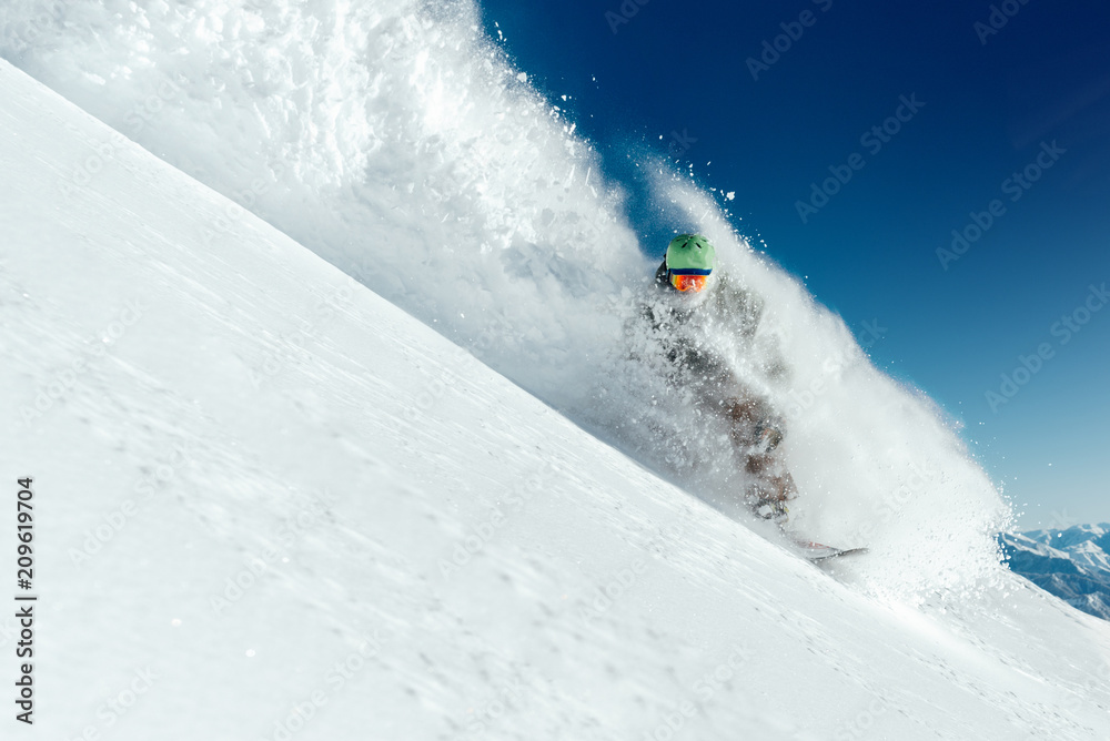 man snowboarder is going very fast in   stream of snow avalanche