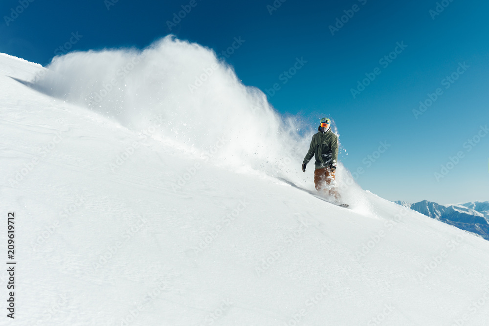 snowboarder in gear brakes on   slope freeride brakes creating a wave of snow