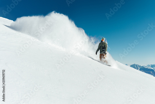 snowboarder in gear brakes on slope freeride brakes creating a wave of snow