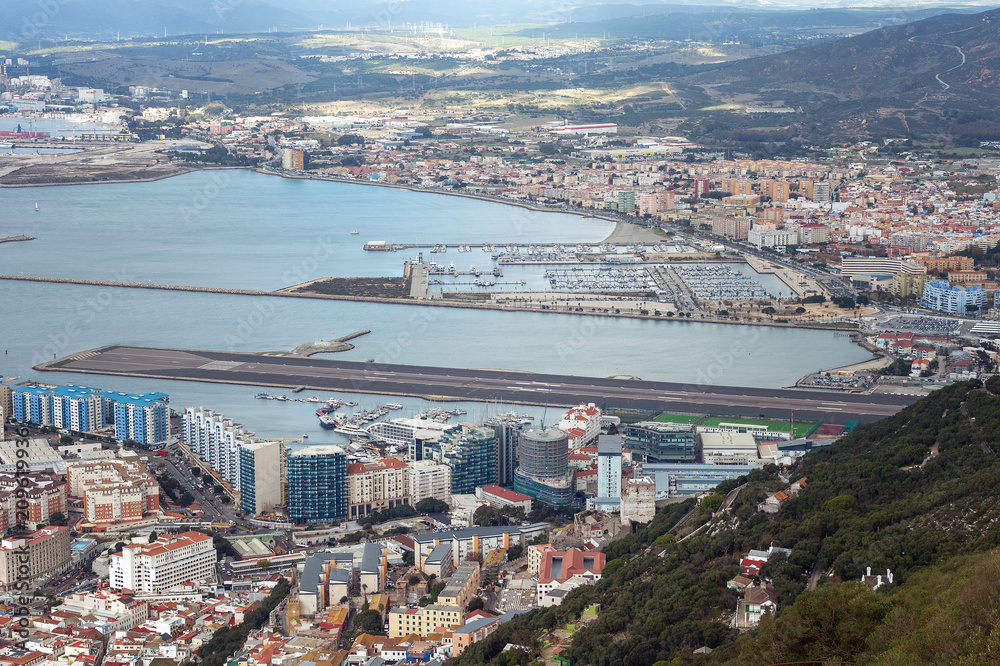 Naklejka premium Aerial view on city and airport runway of Gibraltar and Spanish La Linea town on a background.
