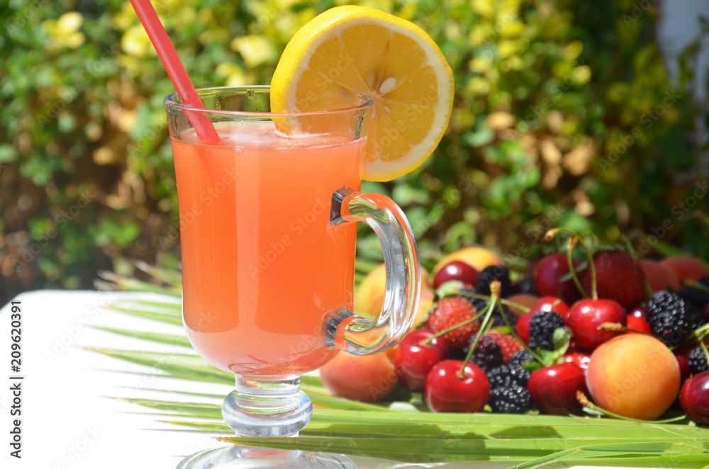 extremely close up glass of tasty tropical alcohol cocktail with berries or lemonade with beautiful decoration on a table in a restaurant with backgrounds of bright colored lights. soft focus. extremely close up glass of tasty tropical alcohol cocktail with berries or lemonade with beautiful decoration on a table in a restaurant with backgrounds of bright colored lights. soft focus.