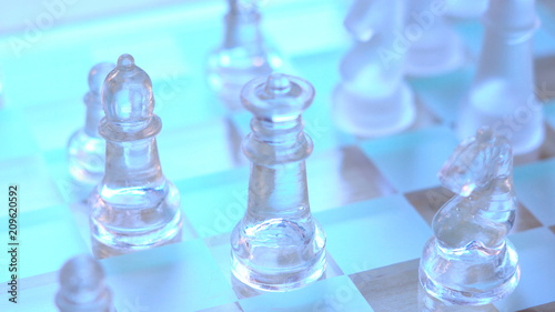 Chess game business concept with glass pieces in natural light, shallow DOF.