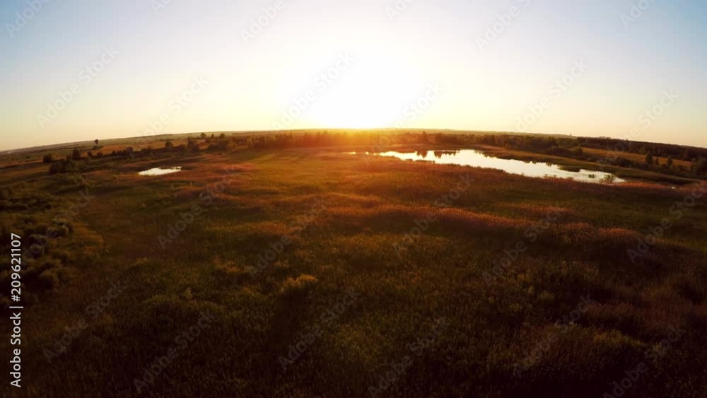 Flight above summer forest and meadow in hot air balloon or drone at sunset, aerial view footage 4K, aerostat travel adventure Flight above summer forest and meadow in hot air balloon or drone at sunset, aerial view footage 4K, aerostat travel adventure