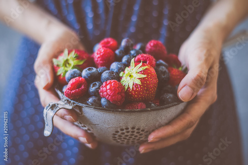 Organic fresh harvested berries. Hands holding fresh juicy berries, closeup