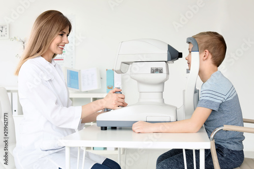 Fotografija Ophthalmologist examining little boy in clinic