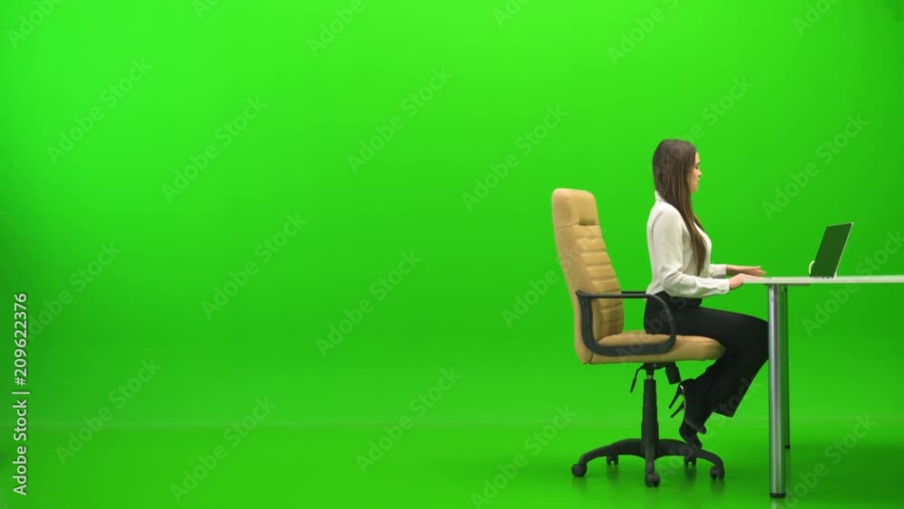 The woman relaxing at the table on the green background