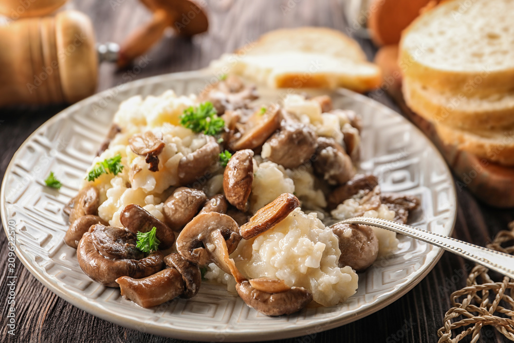 Plate with risotto and mushrooms on wooden table, closeup Plate with risotto and mushrooms on wooden table, closeup