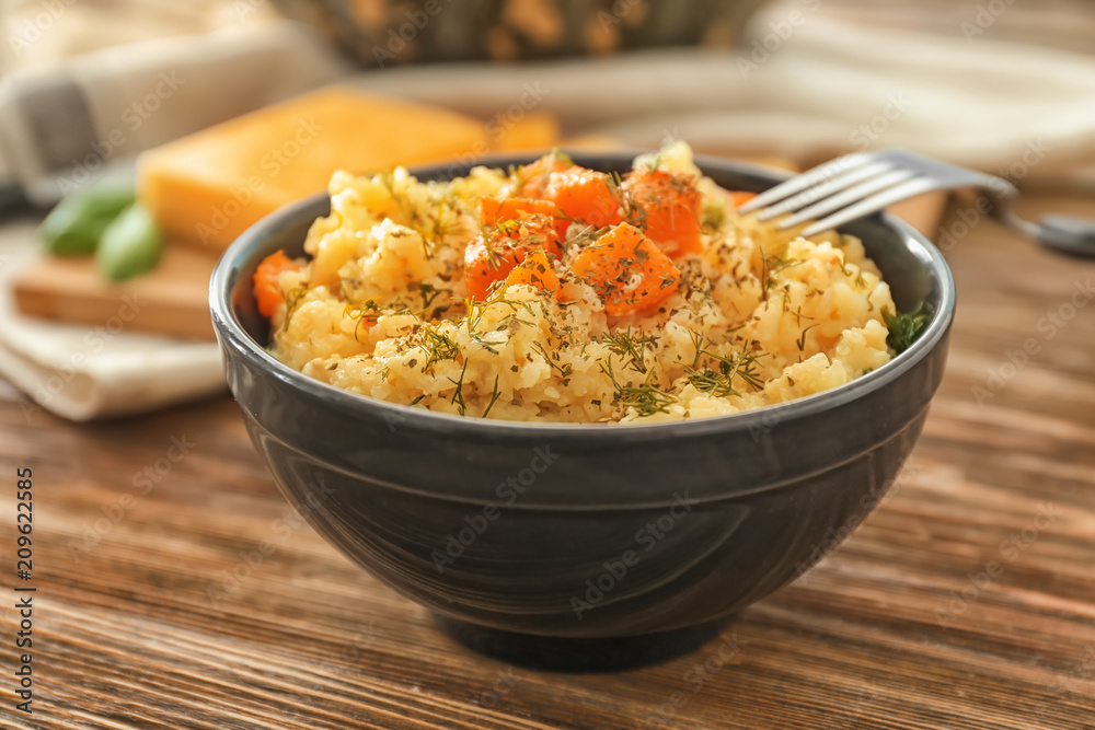 Bowl with delicious pumpkin risotto on wooden table Bowl with delicious pumpkin risotto on wooden table