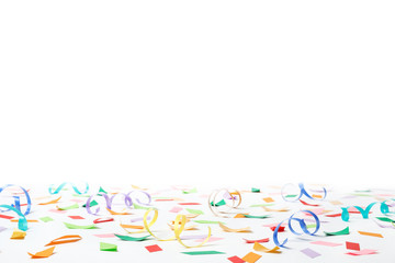 Colorful confetti and streamers on white background