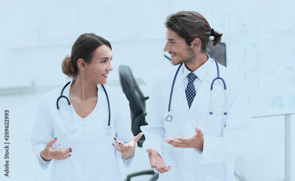 Two Doctors Having Meeting In Hospital Reception Area Two Doctors Having Meeting In Hospital Reception Area