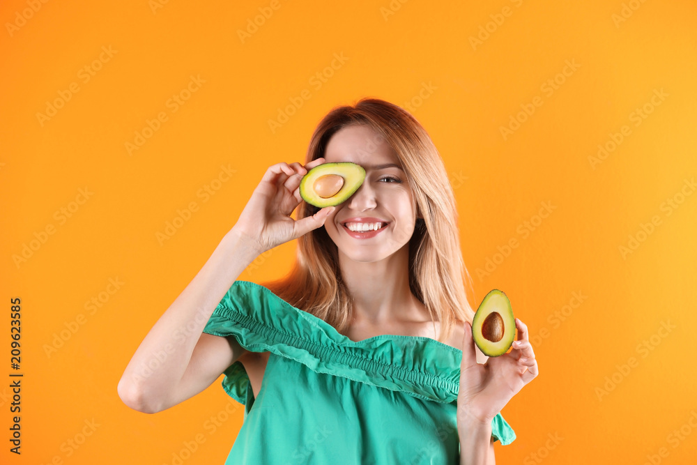 Portrait of young beautiful woman with ripe delicious avocado on color background Portrait of young beautiful woman with ripe delicious avocado on color background