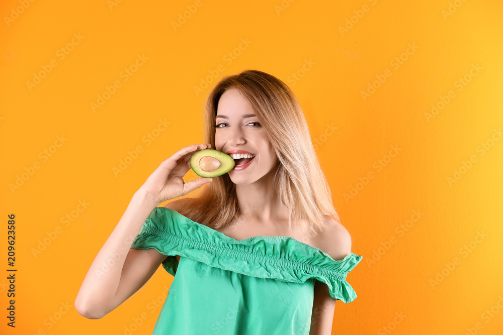 Portrait of young beautiful woman with ripe delicious avocado on color background Portrait of young beautiful woman with ripe delicious avocado on color background