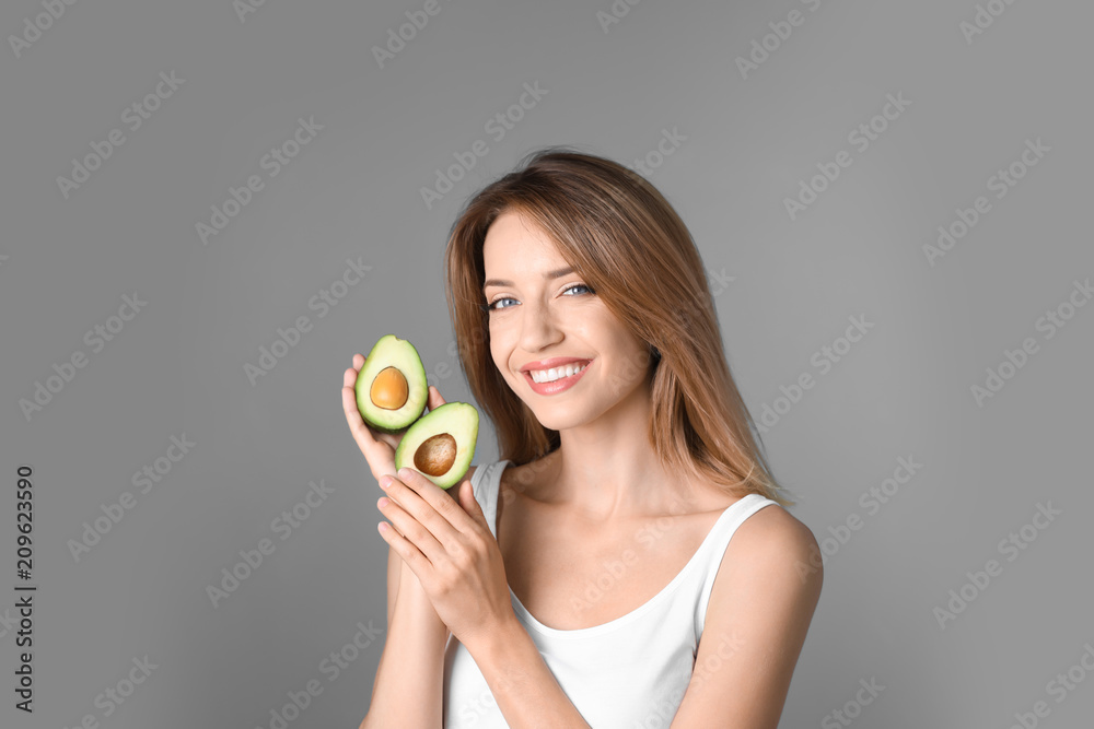 Portrait of young beautiful woman with ripe delicious avocado on color background Portrait of young beautiful woman with ripe delicious avocado on color background