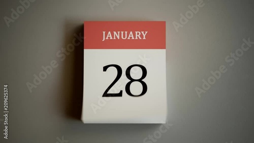 Wall calendar flipping through months and dates on a gray wall