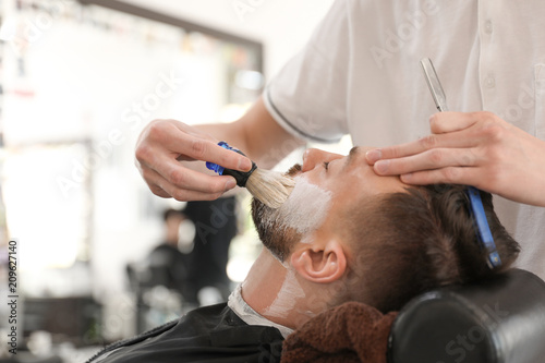 Professional barber working with client in hairdressing salon. Hipster fashion