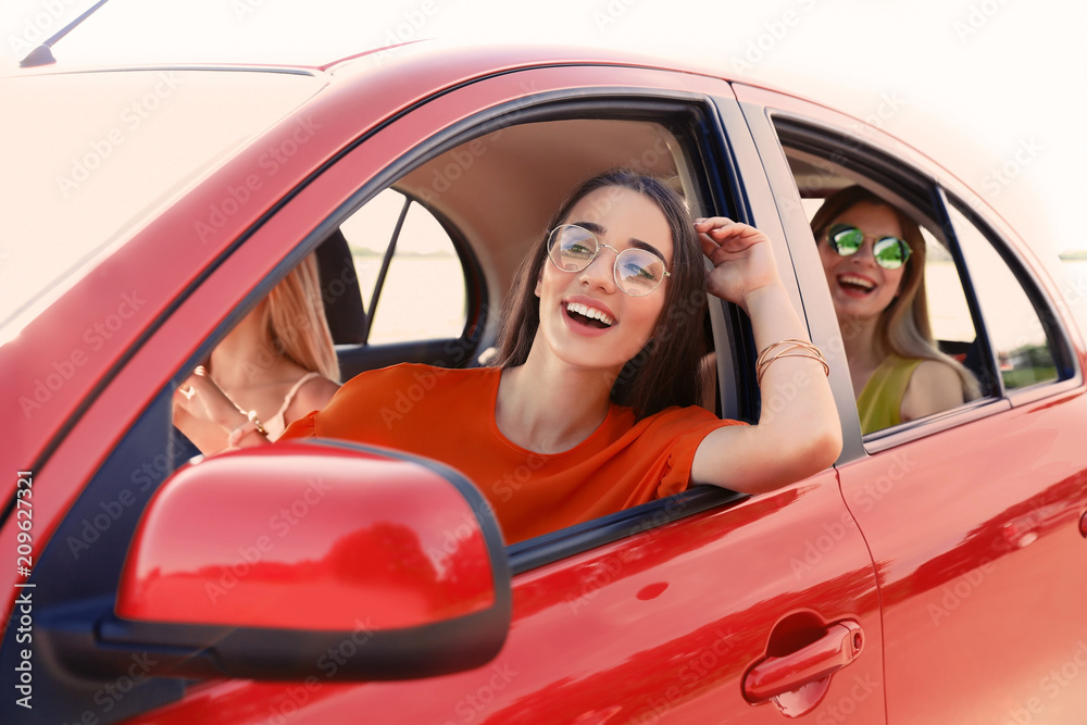 Happy beautiful young women together in car Happy beautiful young women together in car