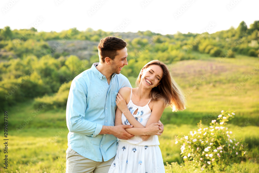 Cute young couple in love posing outdoors on sunny day Cute young couple in love posing outdoors on sunny day