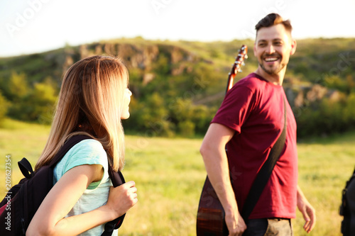 Young people hiking in wilderness. Camping season