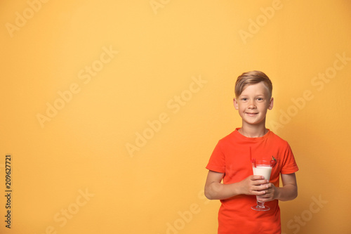 Little boy with glass of milk shake on color background © New Africa