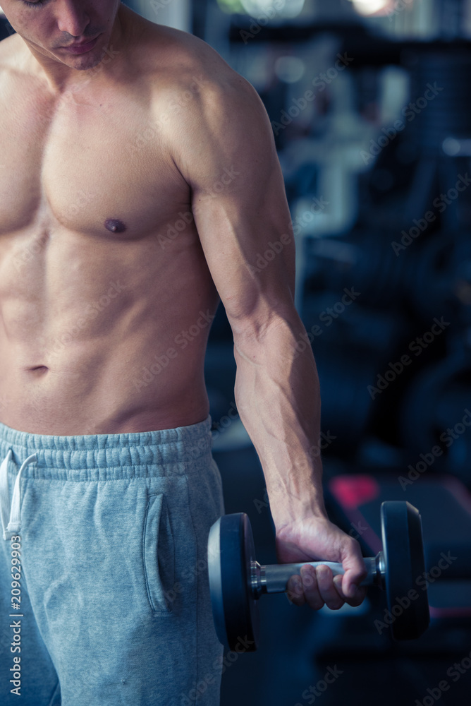 Strong bodybuilder man lifting weights in the sport gym, close up ,bodybuilding and muscle building concept.