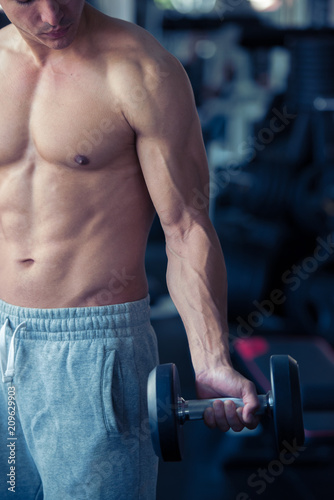 Strong bodybuilder man lifting weights in the sport gym, close up ,bodybuilding and muscle building concept.