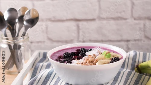 Healthy breakfast bowl: blueberry smoothie with banana, cococnut and blackberries. photo