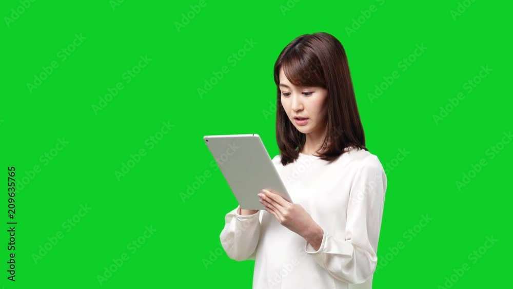 Young asian woman using tablet pc. Green background for Chroma keying. Young asian woman using tablet pc. Green background for Chroma keying.