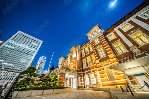 Asia Business concept for real estate and corporate construction - looking up view of panoramic urban city skyline view and tokyo station under twilight sky and neon night in tokyo, Japan