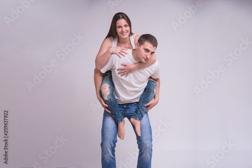 Portrait of beautiful brunette girl and young guy on white background in family happiness