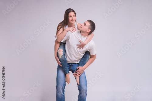 Portrait of beautiful brunette girl and young guy on white background in family happiness