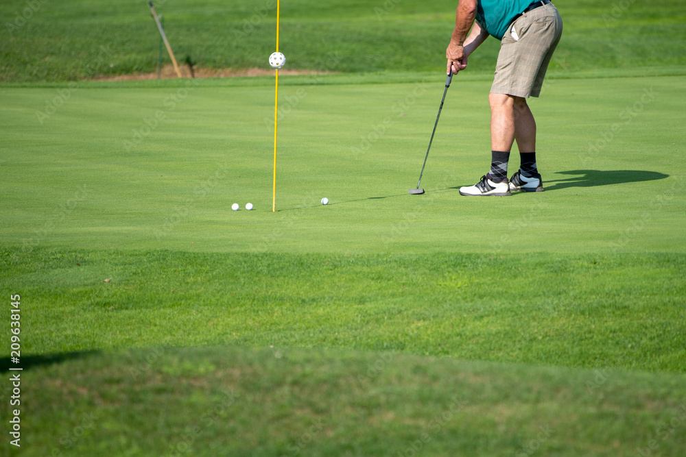 Obraz premium Golfer on the green, mature male, not recognizable, copyspace