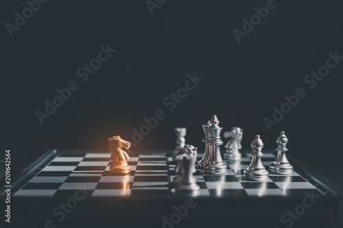 Chess pieces knights facing each other on chessboard.