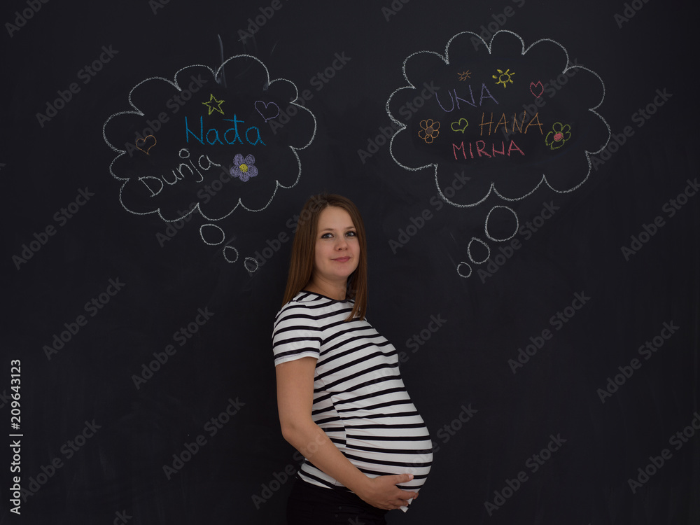 pregnant woman thinking in front of black chalkboard