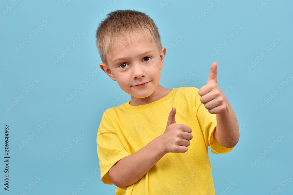The boy is good. A teenage boy is holding his fingers up. The boy is good. A teenage boy is holding his fingers up.