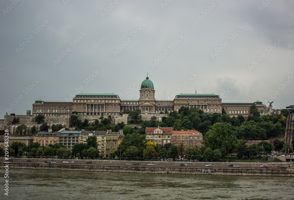 Budapest castle architecture facade with river Danube on foreground in gray rainy day