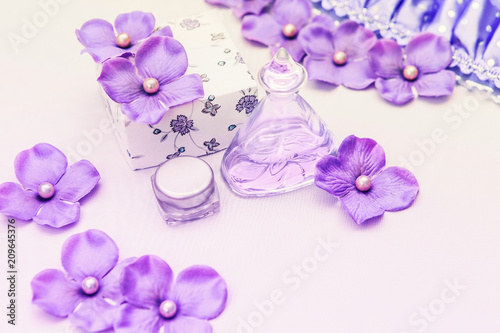 perfume bottle with a box and some purple and pink decorations on white background, woman cosmetics