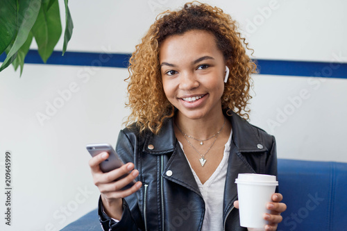 Young african american woman wearing wireless headphones. photo