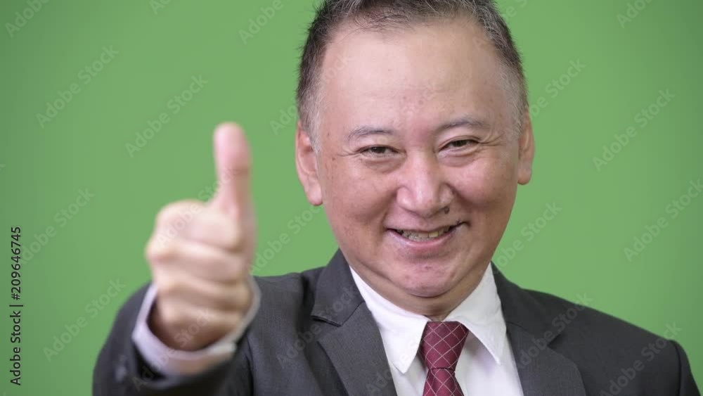 Mature Japanese businessman giving thumbs up Mature Japanese businessman giving thumbs up