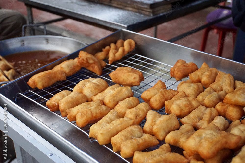 Chinese dough or deep fried dough in the stainless steel tray for sell in morning market of Thailand Chinese dough or deep fried dough in the stainless steel tray for sell in morning market of Thailand