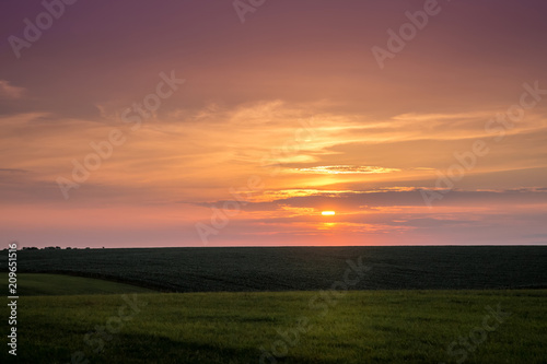 Scenic sunset on the plain. The dark sky during the sunset_