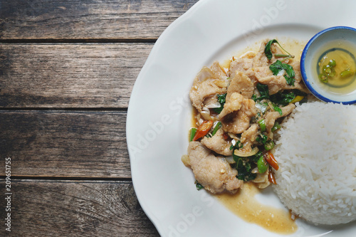 Stir-fried pork and basil on the wooden table